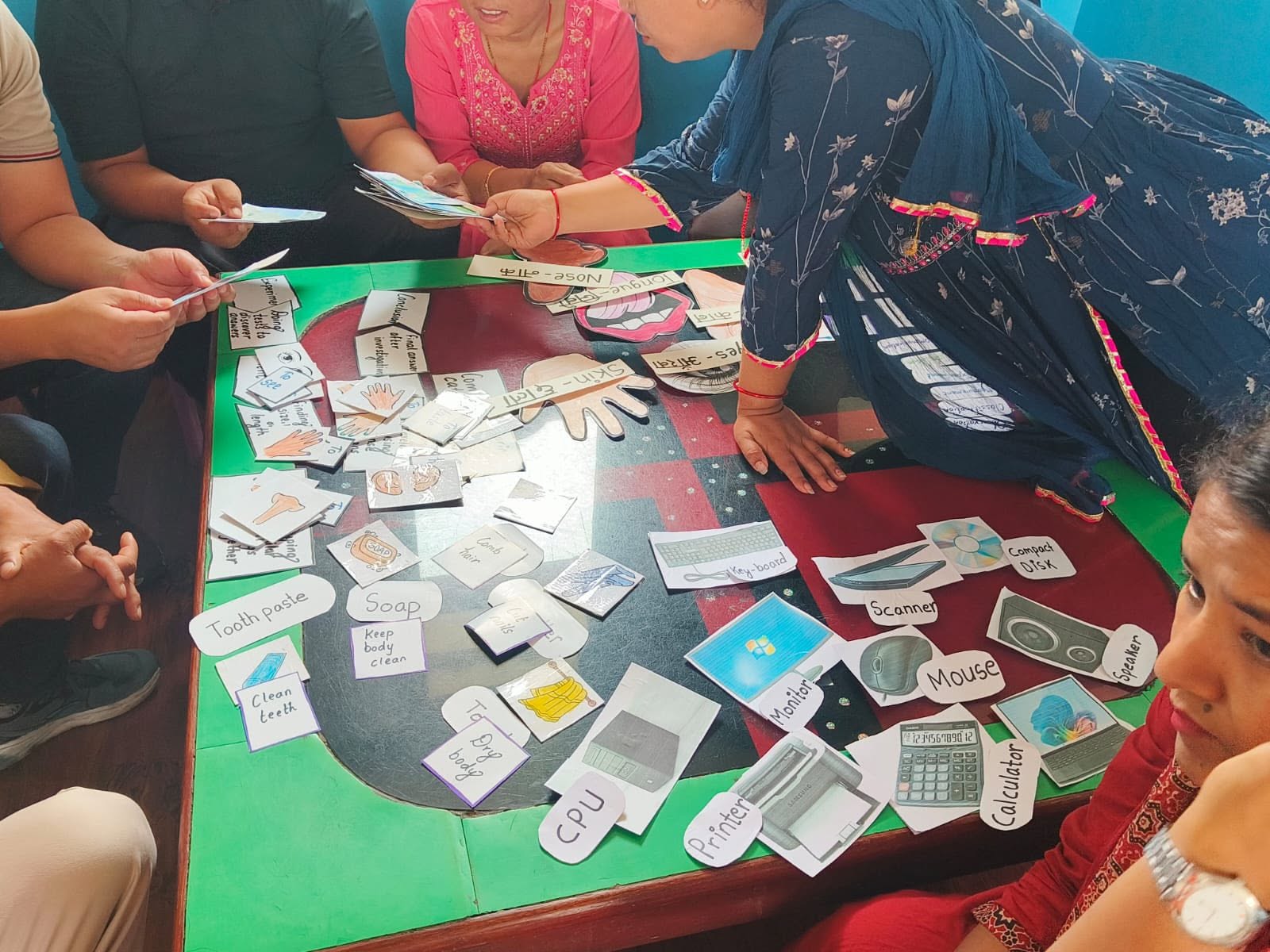 Teachers arranging hand-made flashcards and teaching materials during a workshop