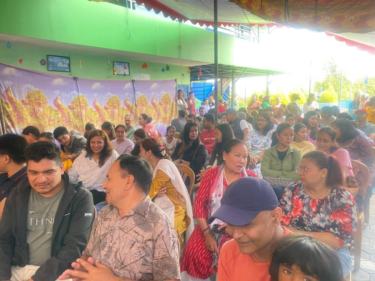 Parents and guests seated under a decorated canopy at a Heimric school programme
