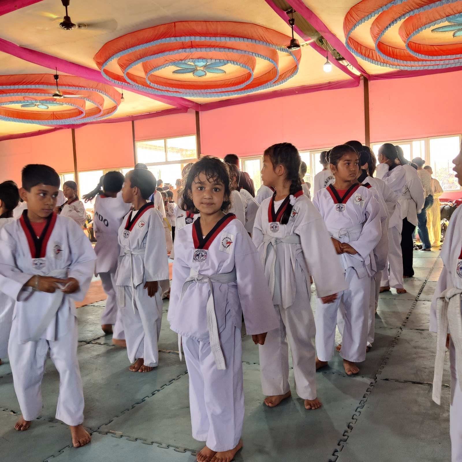 Heimric children in white taekwondo uniforms training in the school hall